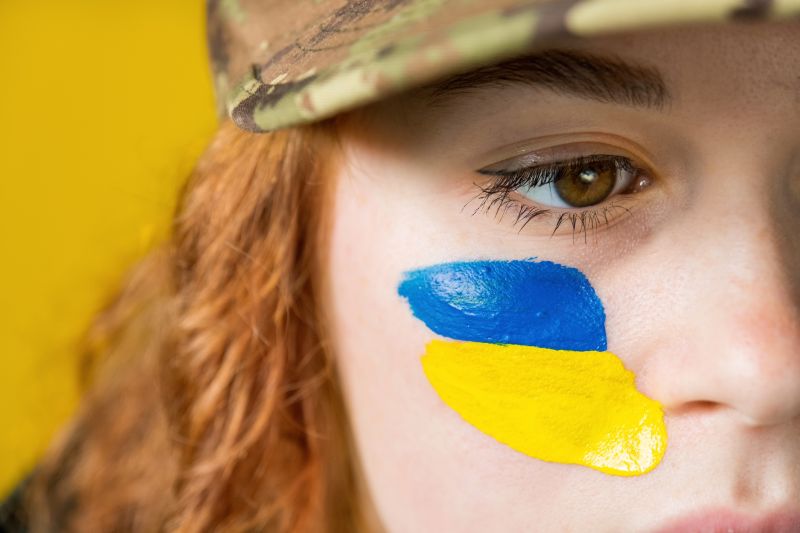 Woman with national flags of Ukraine on her cheeks